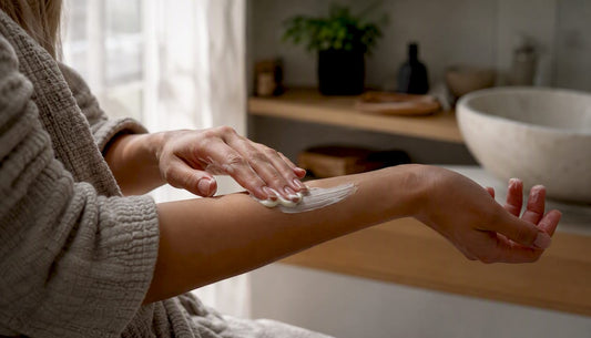 Hands applying rich body butter on arm