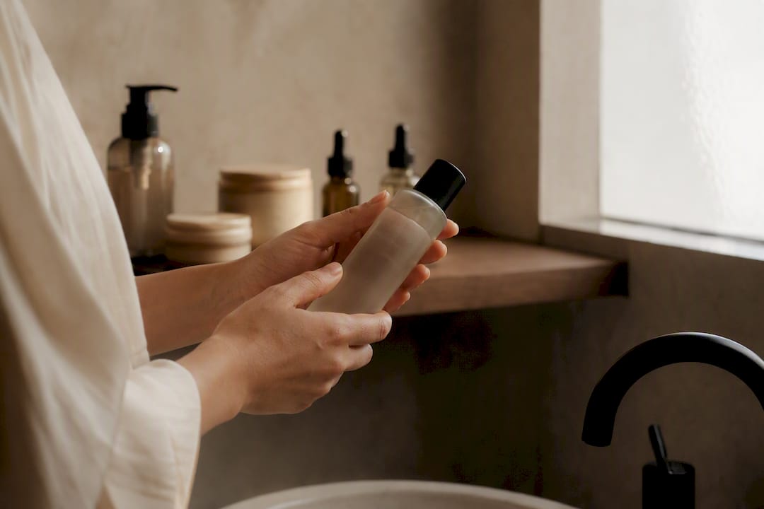 Hands reading skincare label close-up