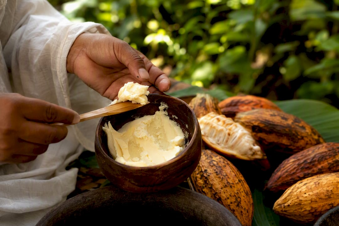 Hands scooping natural cocoa butter