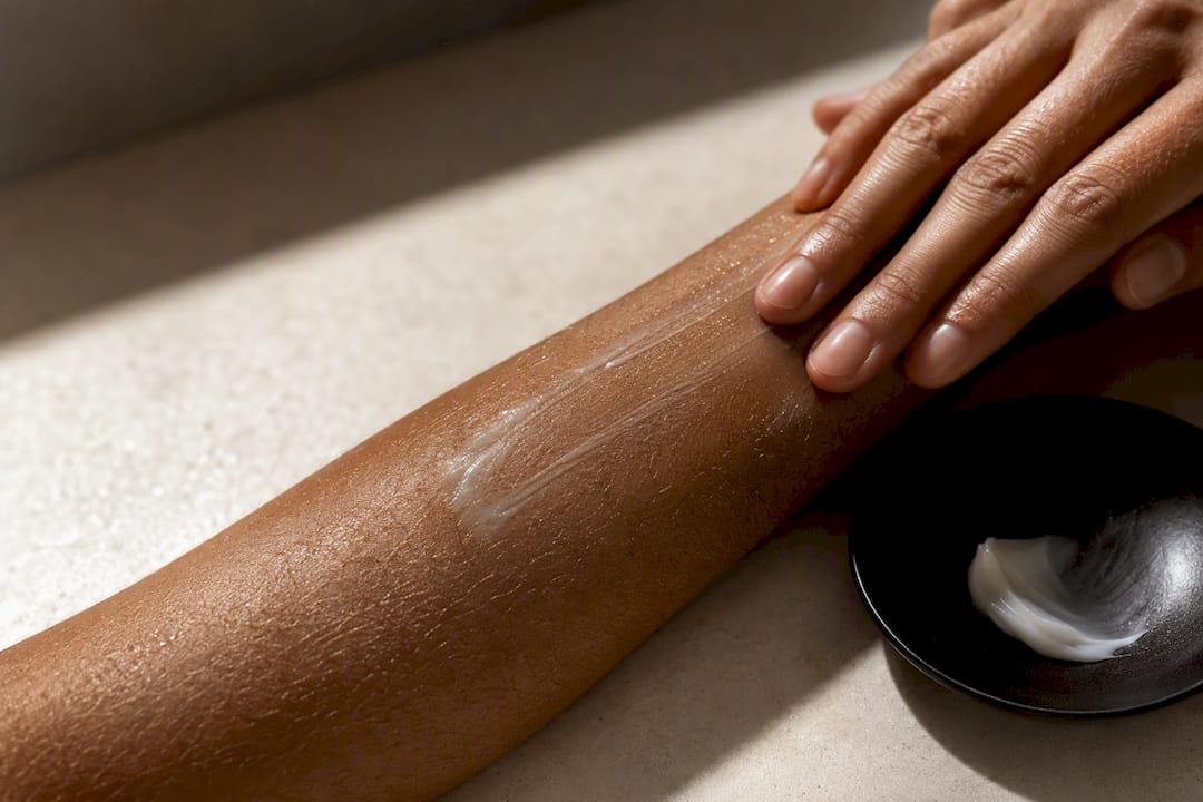 Moisturiser being gently applied to dry forearm