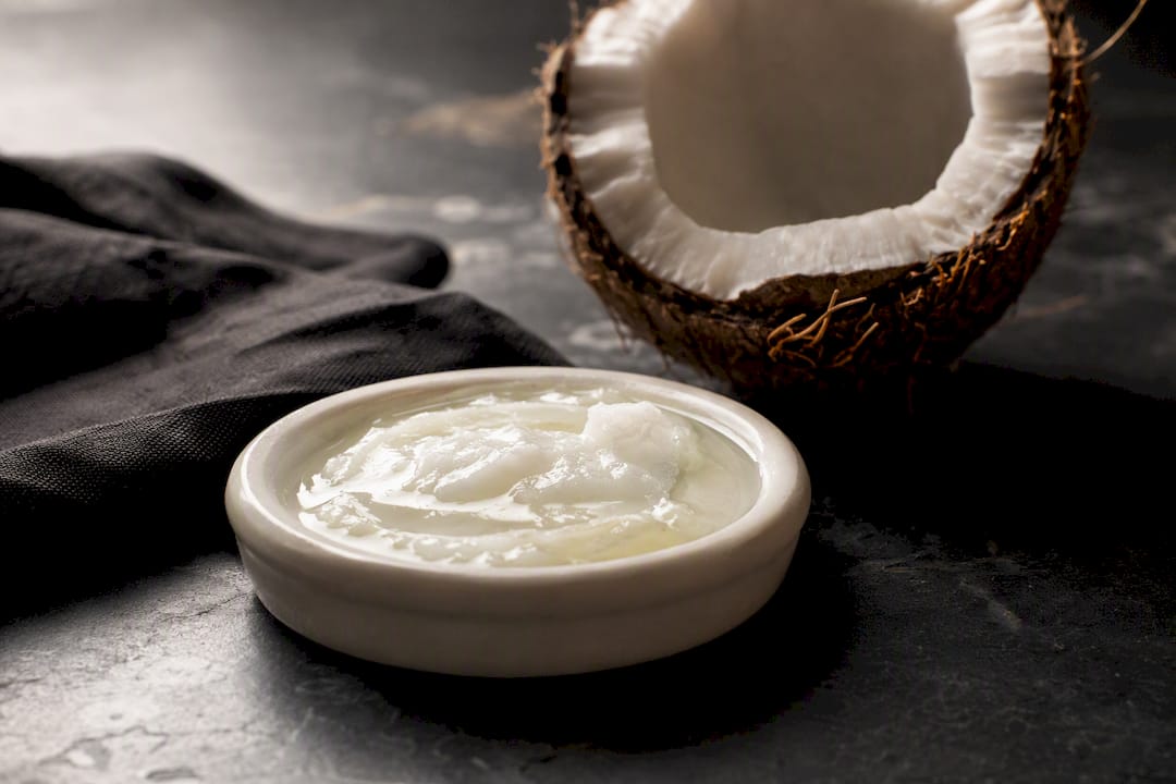 Coconut oil beside an opened coconut