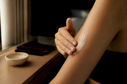 Person applying body butter to upper arm